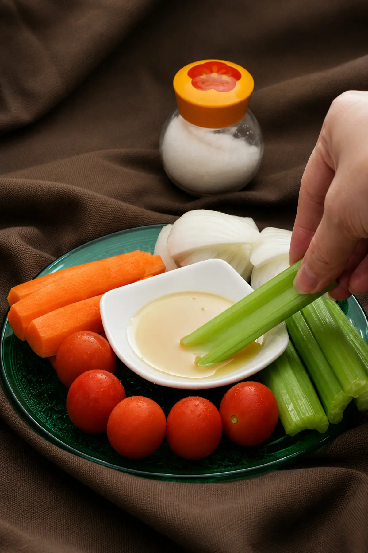 Celery stick being dipped into Pinzimonio sauce.