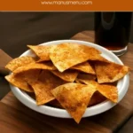 Baked homemade Doritos piled in a white bowl.