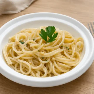 Pasta with Garlic and Parsley served in a white ceramic bowl.