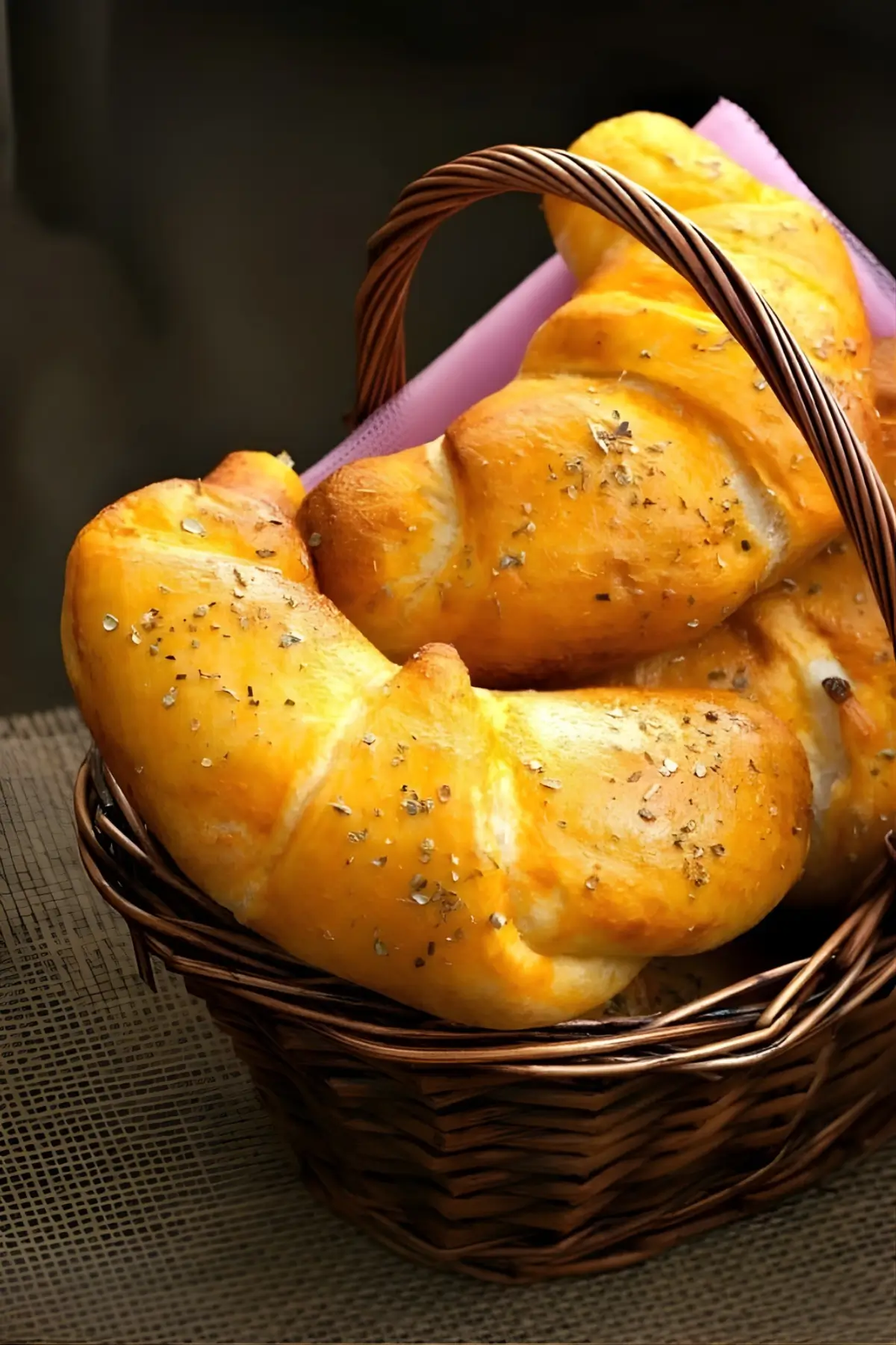 Baked savoury croissants arranged in a wicker basket.