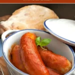 Italian sausages in rich tomato sauce inside a white casserole.