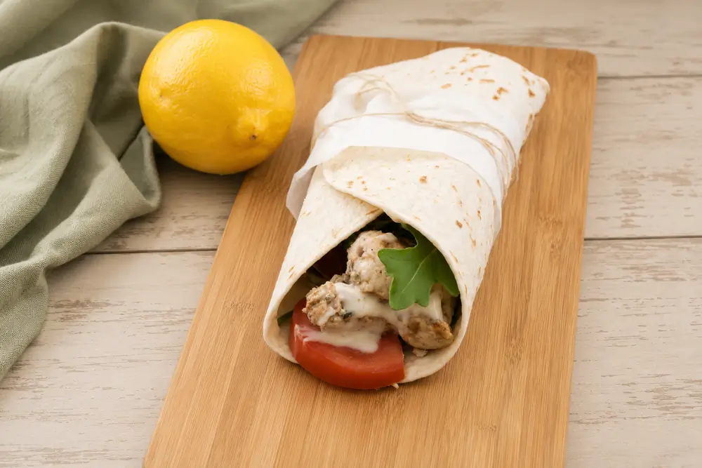 Lemon Chicken Wrap with Aioli filled with grilled chicken, rocket, sliced tomato and homemade aioli.