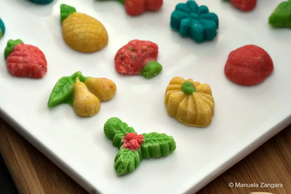 Close-up of Goan marzipans shaped like fruit and leaves on a white tray.