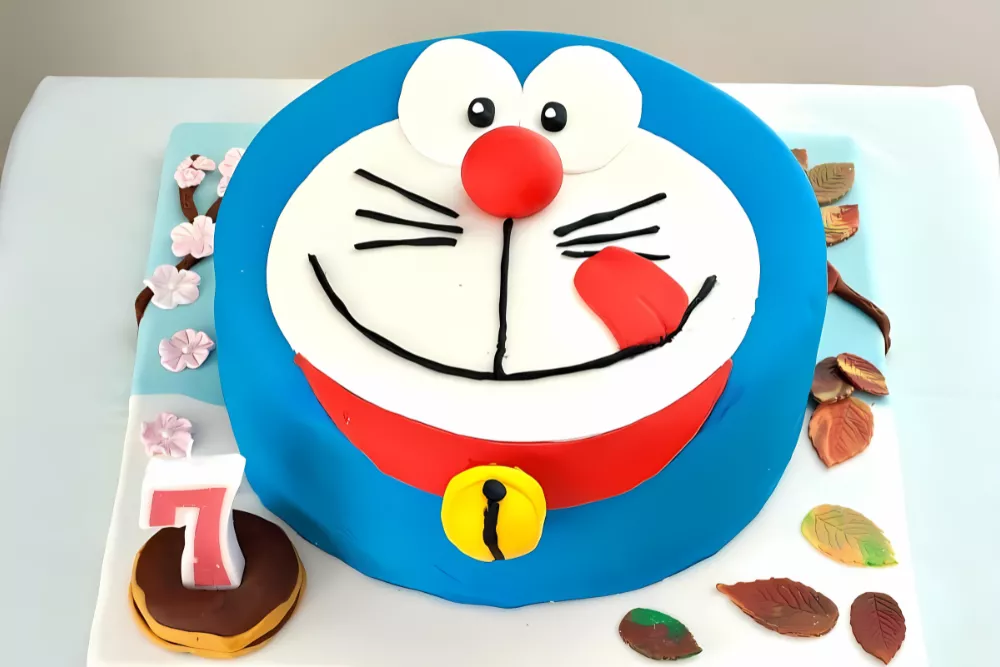 Front view of Doraemon fondant cake with cherry blossoms, autumn leaves, and a number 7 candle.