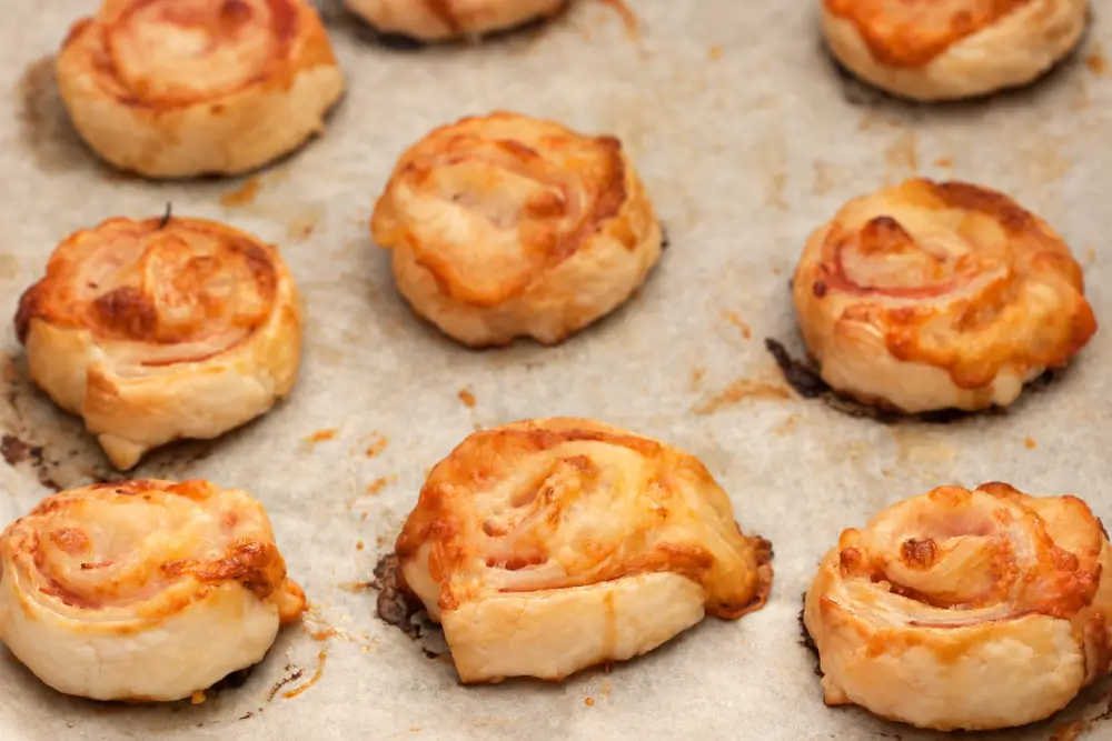 Ham and Stracchino Pinwheels on parchment paper.