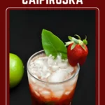 Strawberry Caipiroska cocktail with crushed ice, fresh strawberries, and a whole lime on the side.