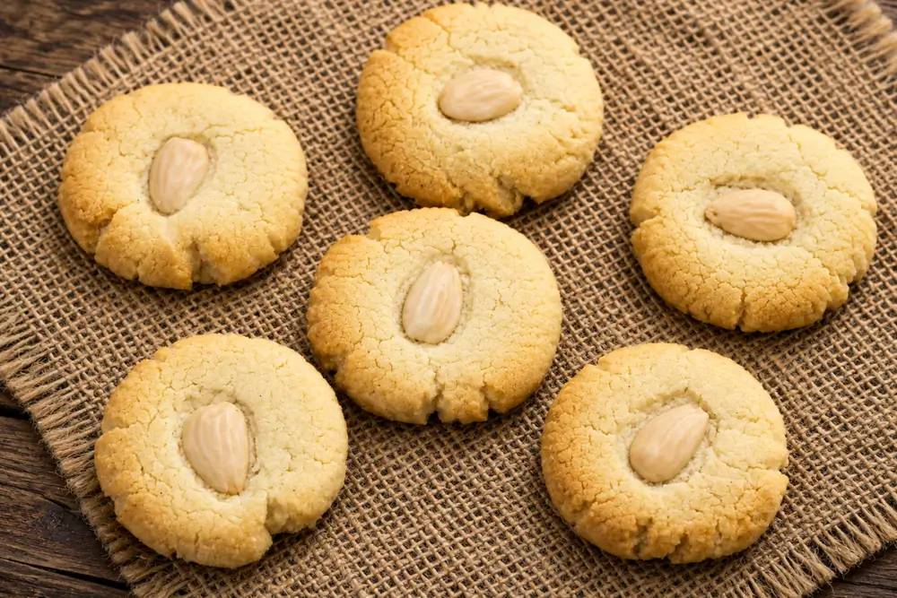 Baked almond cookies arranged on a rustic hessian mat.