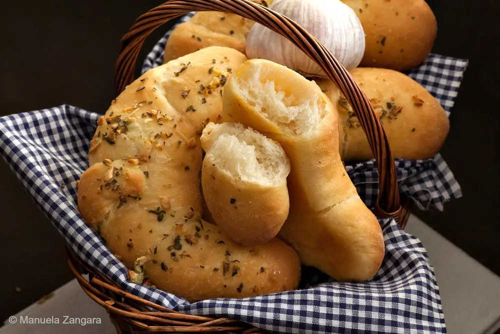 Baked Italian garlic croissants served in a bread basket.