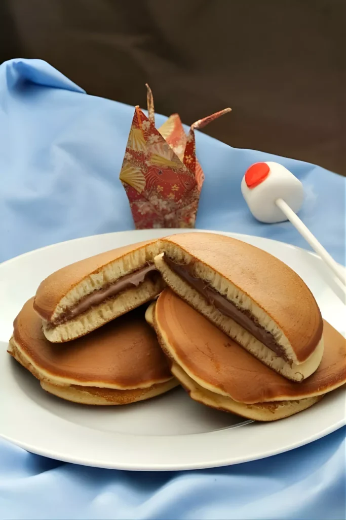 Nutella Dorayaki pancakes filled with creamy Nutella, served on a white plate.