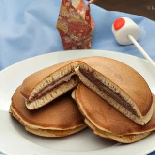 Plate of Nutella Dorayaki pancakes filled with creamy Nutella, served on a white plate with Japanese decor in the background.