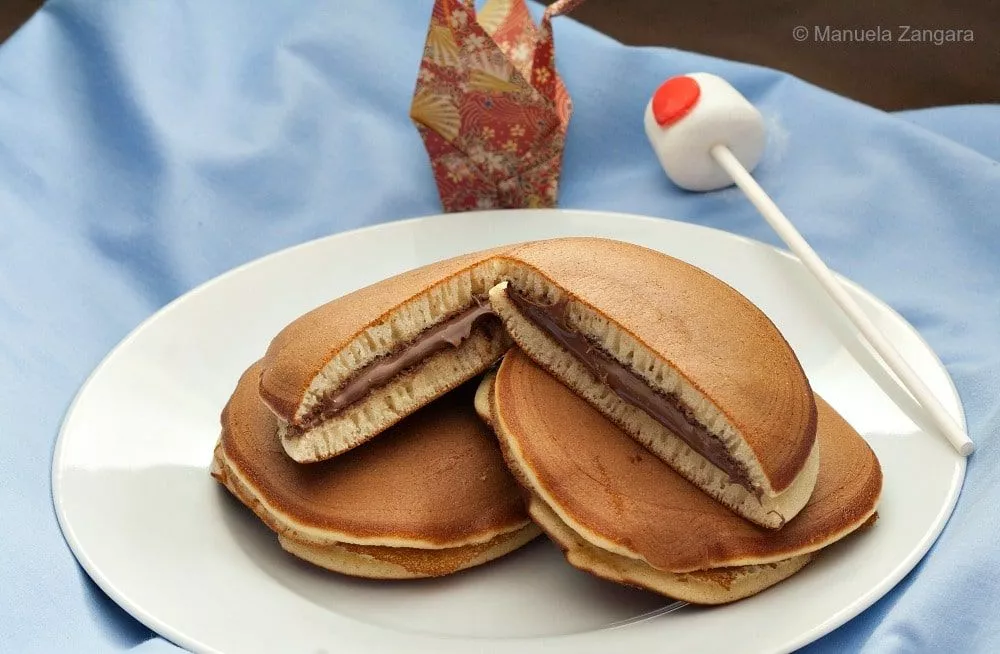 Plate of Nutella Dorayaki pancakes filled with creamy Nutella, served on a white plate with Japanese decor in the background.