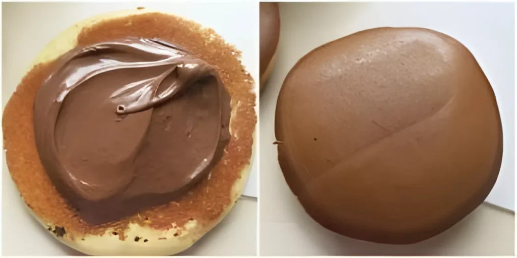Spreading Nutella filling on one pancake before closing to make the Dorayaki sandwich.