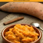 Homemade sweet potato mash in a ceramic bowl with a spoon on the side.