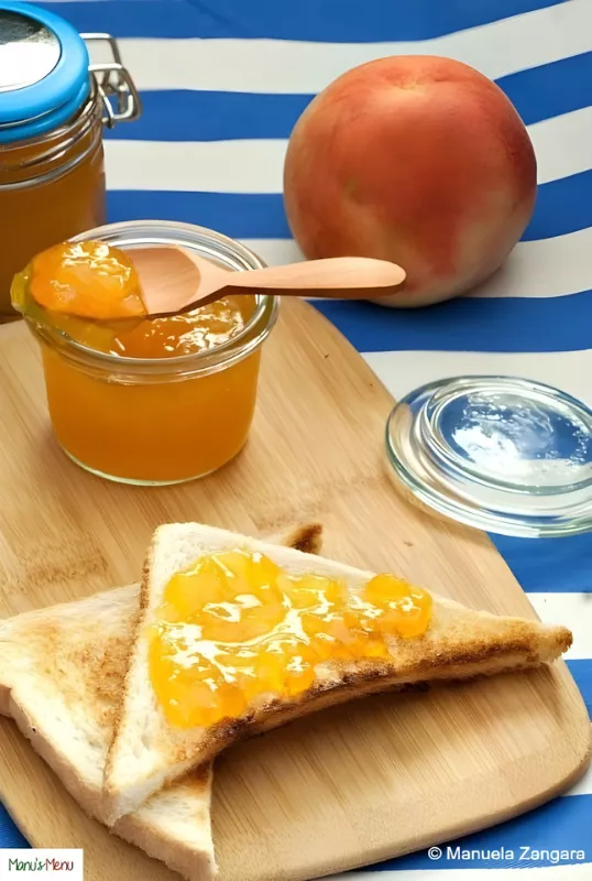 Toasted bread with homemade peach jam beside a jar and fresh peach.