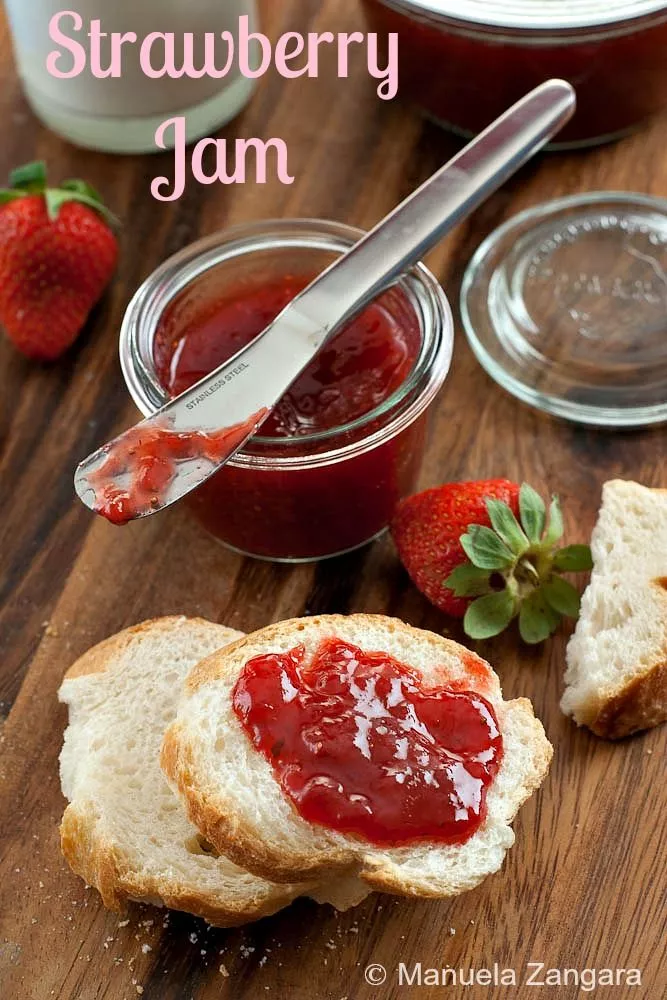 Slice of bread topped with strawberry jam beside fresh berries, a classic fruit jam treat.