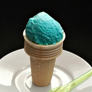 Close-up of a blue Gelato al Puffo scoop in a wafer cone.