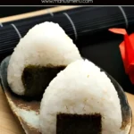 Two triangle onigiri wrapped with nori on a plate.