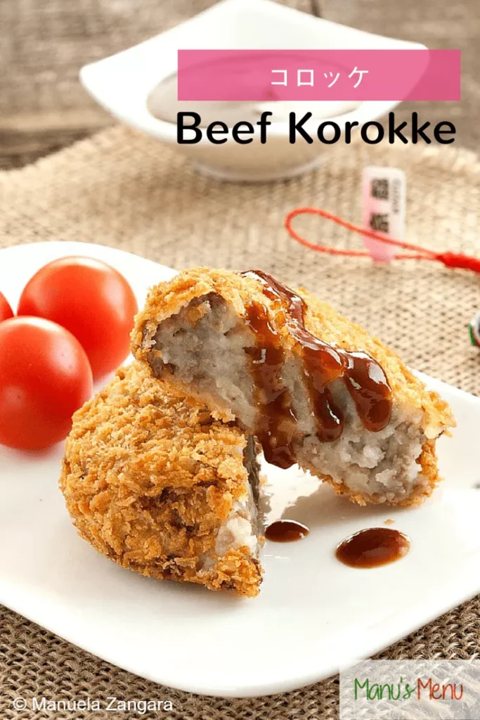 Golden fried beef korokke cut open to show soft potato filling with sauce on top.