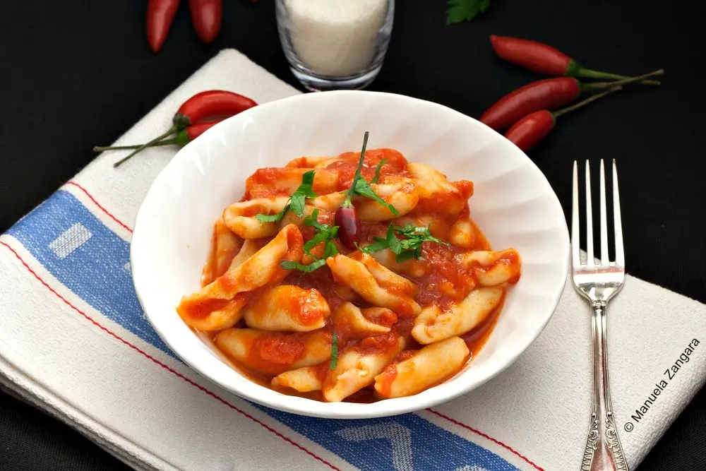 Bowl of cicatelli pasta coated in spicy tomato sauce.