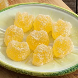 Close-up of orange and lemon jelly candies coated in sugar.