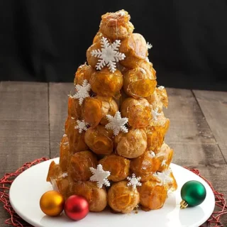 Traditional French Croquembouche made with caramel-coated cream puffs arranged in a cone shape.