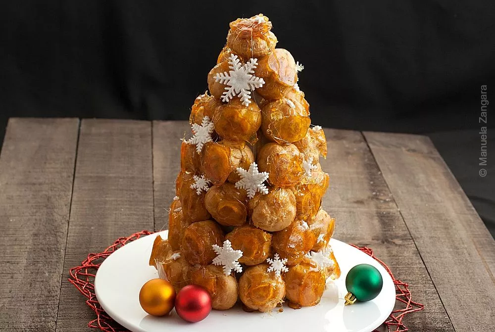 Traditional French Croquembouche made with caramel-coated cream puffs arranged in a cone shape.