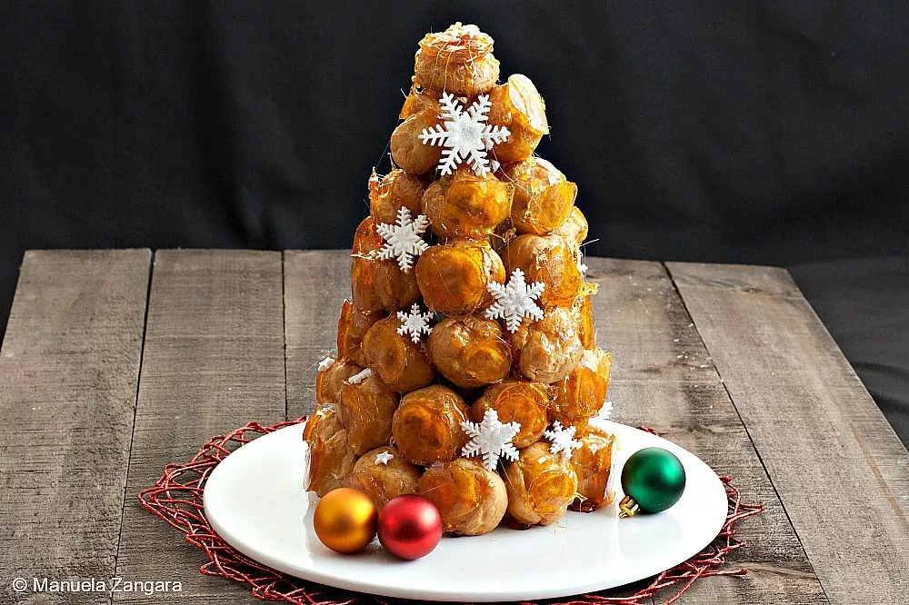 Finished Croquembouche tower decorated with caramel threads and snowflakes.