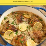Lemon Chicken and Rice topped with lemon slices and parsley in a blue Dutch oven.