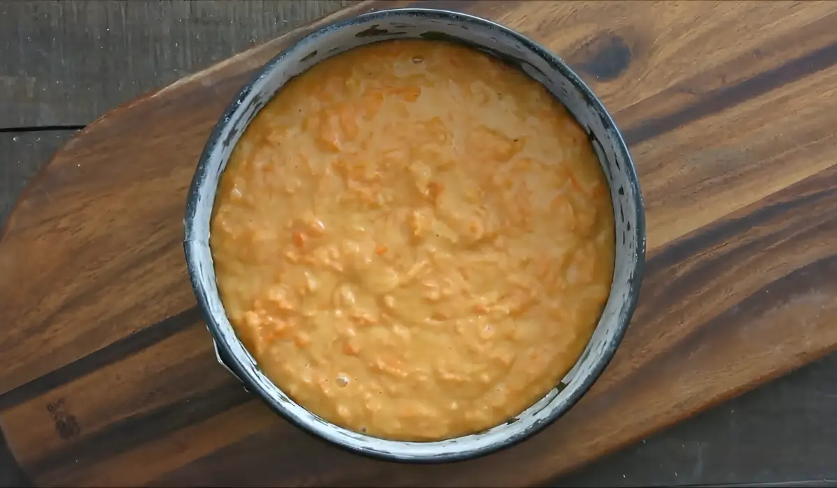 Raw almond carrot cake batter spread evenly inside a springform tin.