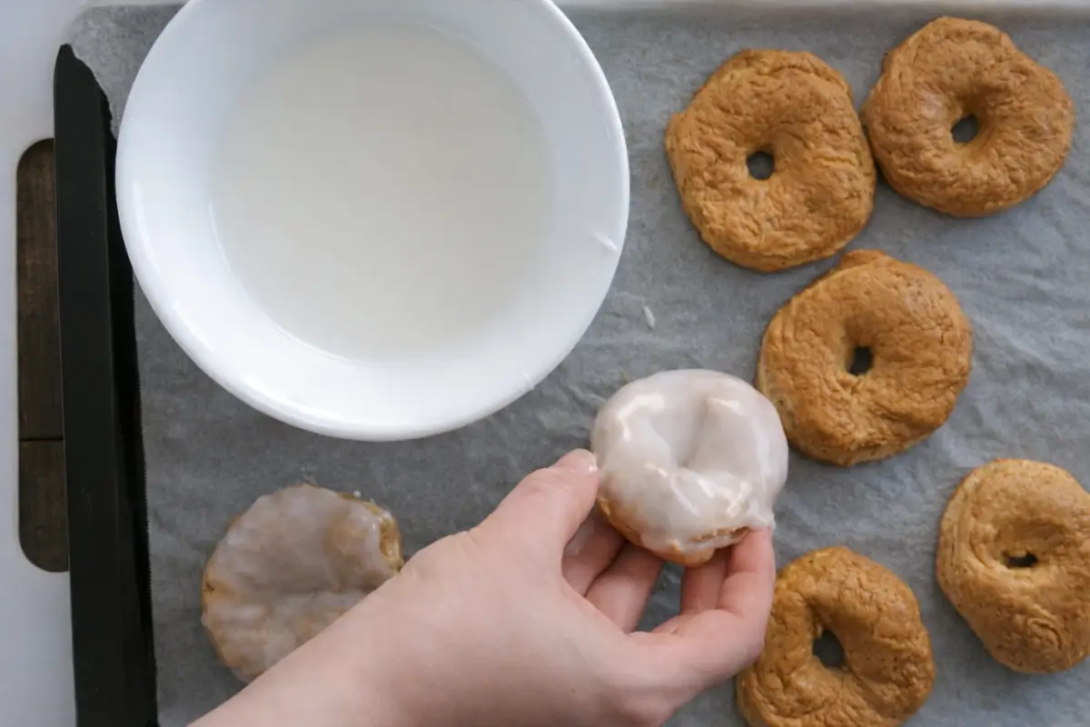 Hand dipping Italian Easter taralli into a smooth icing glaze.