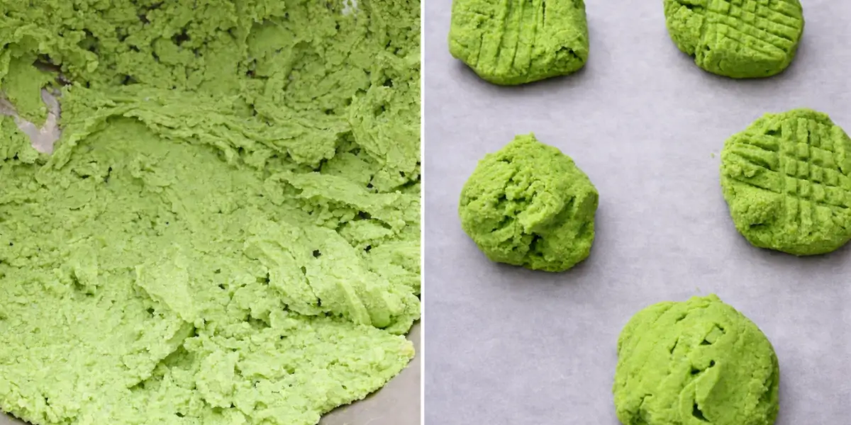 Bright green buttercream dough in a mixing bowl and spooned portions pressed with a fork on lined baking paper.
