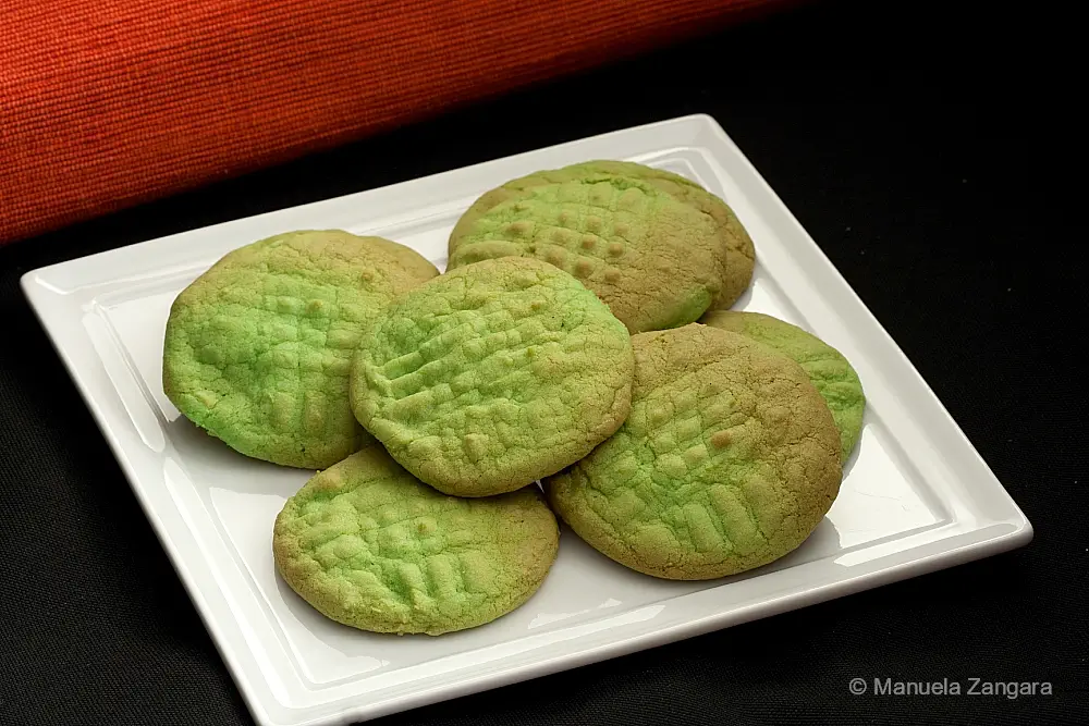 Green Buttercream Cookies with golden edges served on a white square plate.