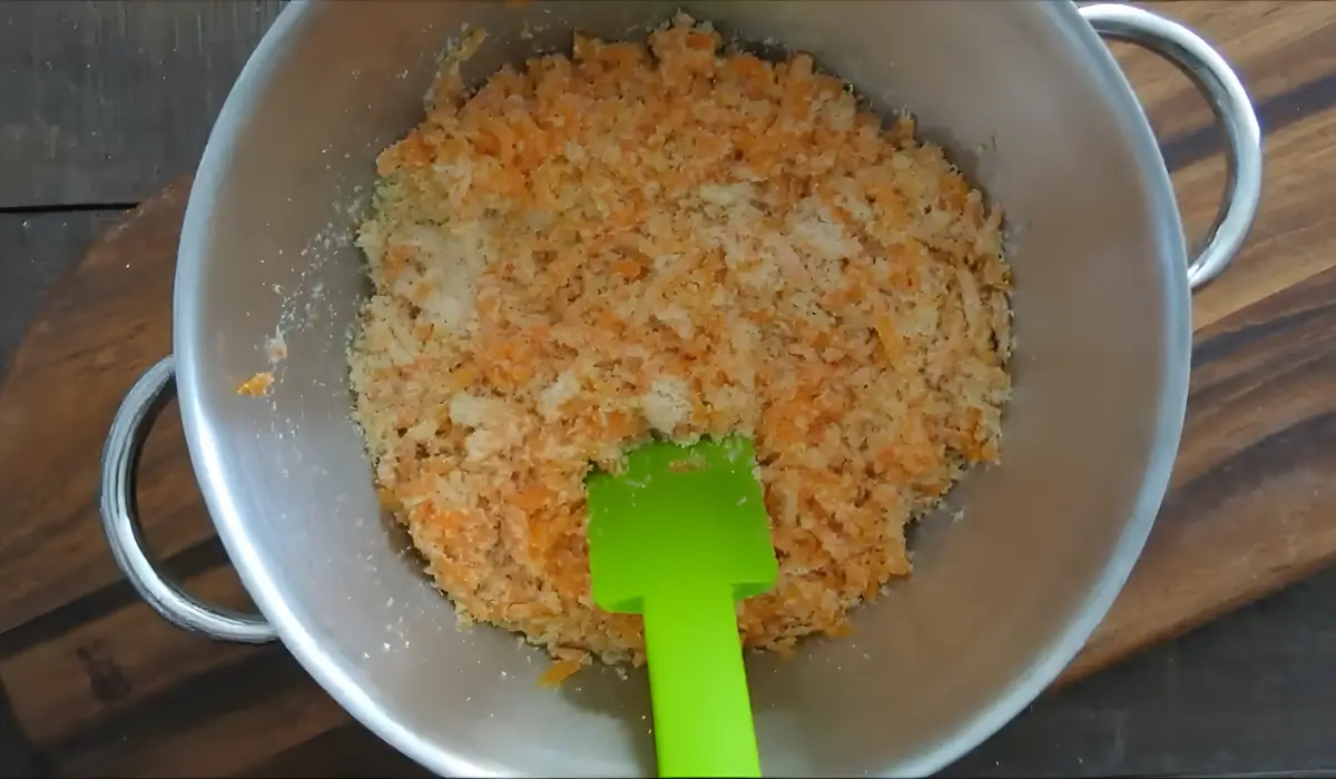 Grated carrots, almond meal, and sugar mixed together in a bowl.