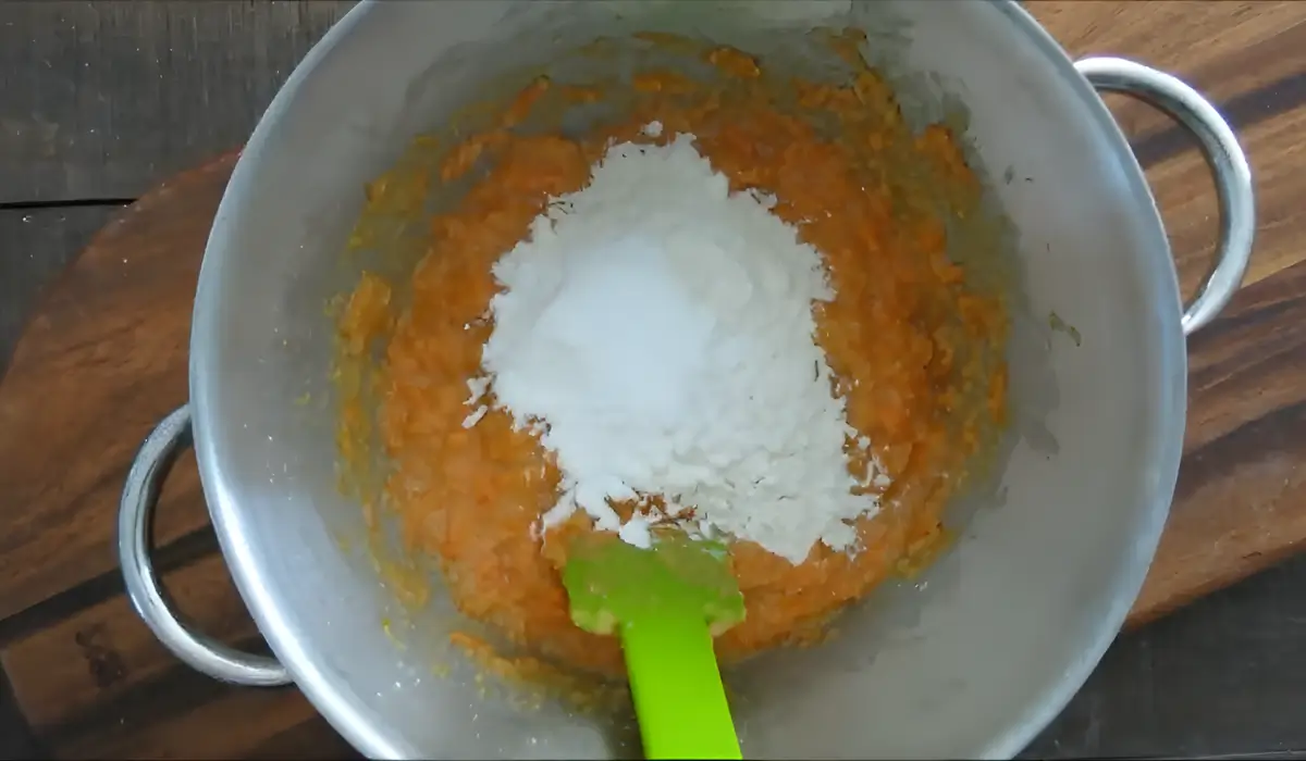 Flour and baking powder added to the carrot mixture before stirring.