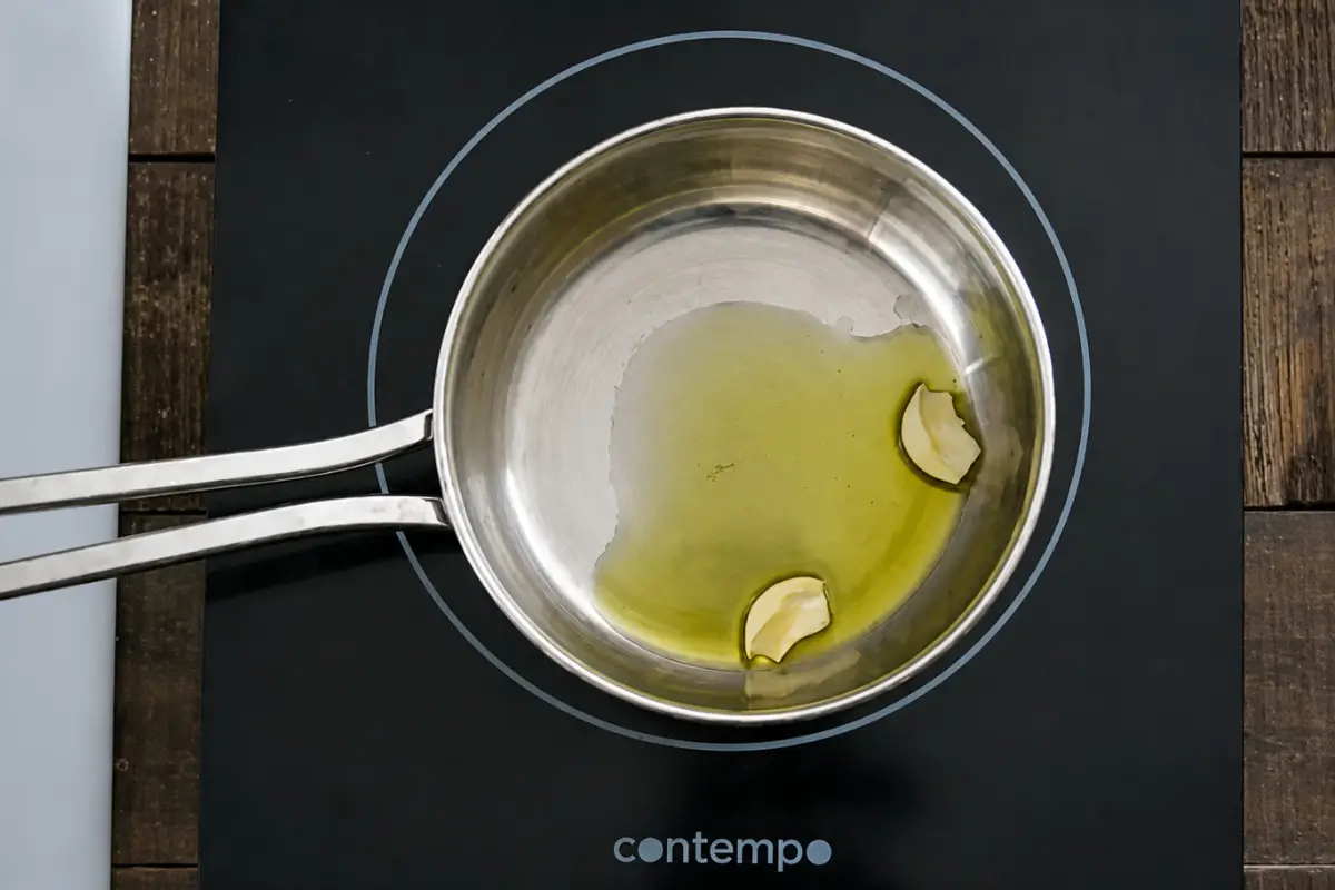 Garlic gently cooking in olive oil before preparing the tomato tuna sauce.