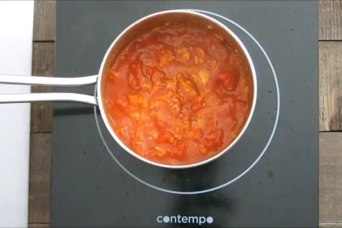 Tomato and tuna sauce simmering in a pot on the stove.