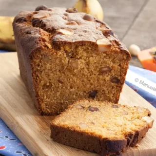 Sliced papaya banana bread showing the soft crumb and toasted macadamias inside.