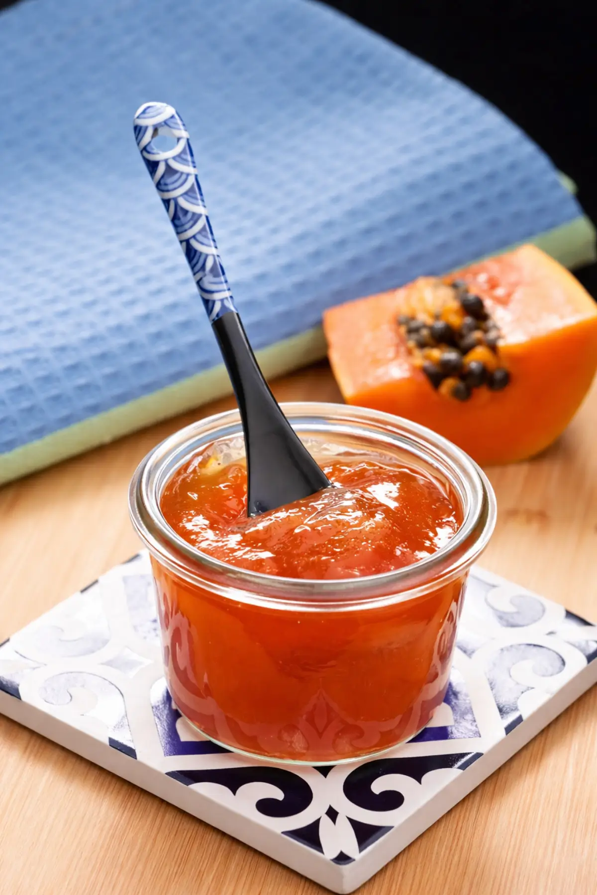 Papaya jam in a jar with a spoon.