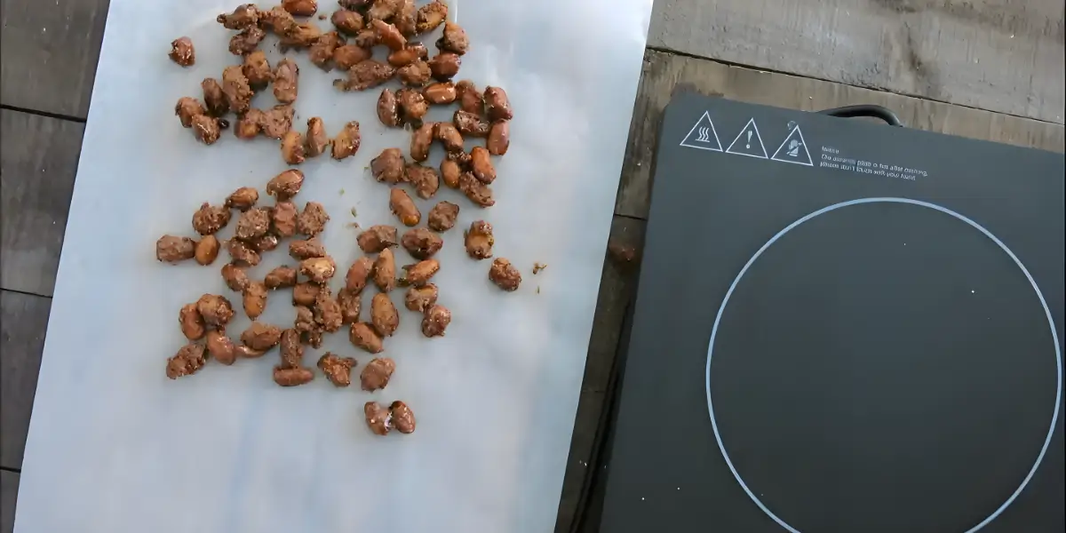 Almond pralines cooling on a baking paper–lined tray.