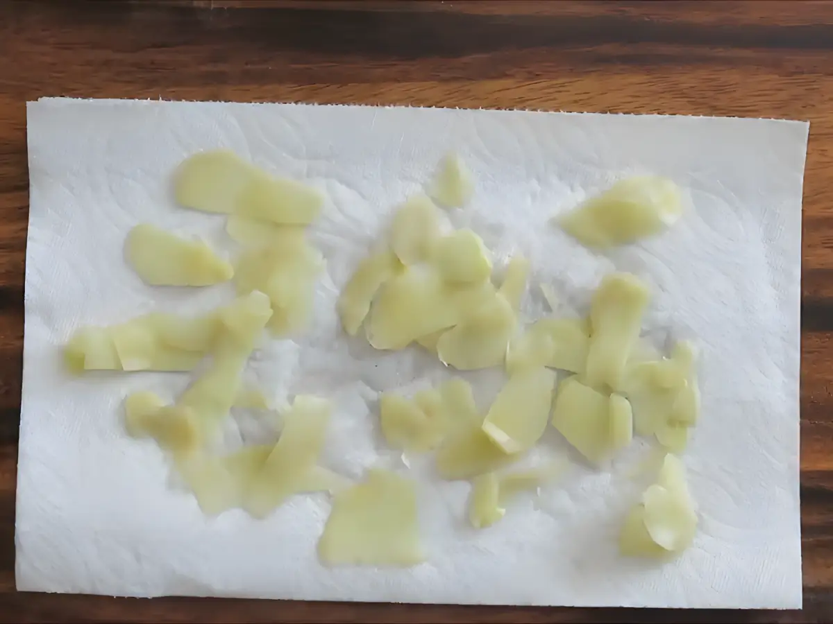 Cooked ginger slices spread out on kitchen paper to dry.