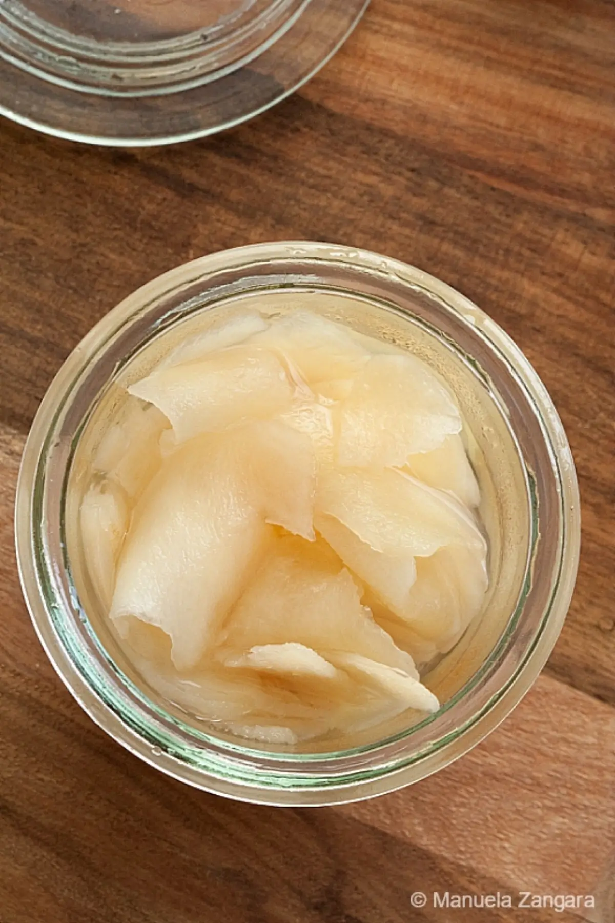 A jar filled with pale, thinly sliced Japanese pickled ginger viewed from above.