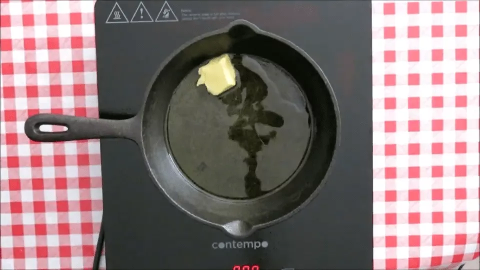Butter melting in a skillet with olive oil on a stovetop.
