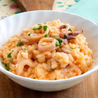 Calamari Risotto served in a bowl, creamy and finished with fresh parsley.