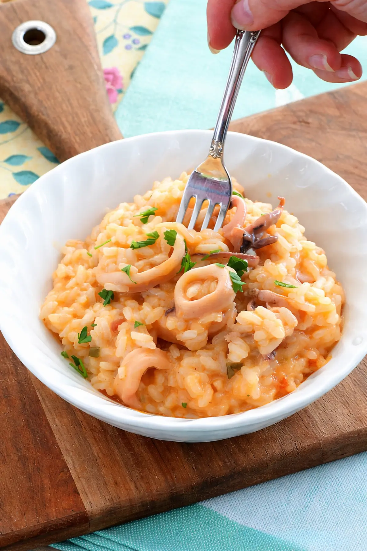 Close-up of calamari risotto as a fork lifts a portion.