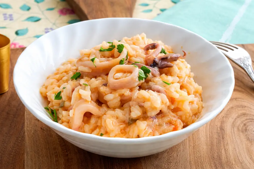 Calamari Risotto served in a bowl, creamy and finished with fresh parsley.