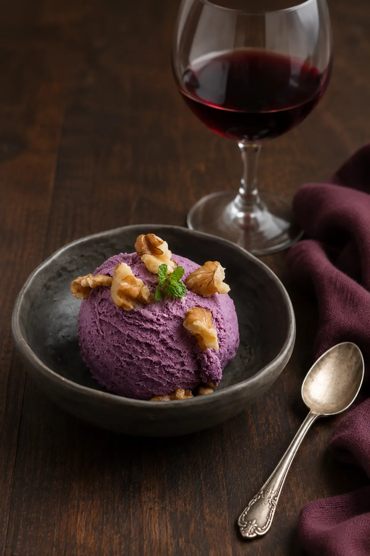 Creamy frozen dessert topped with walnuts, served with a glass and bottle of red wine.