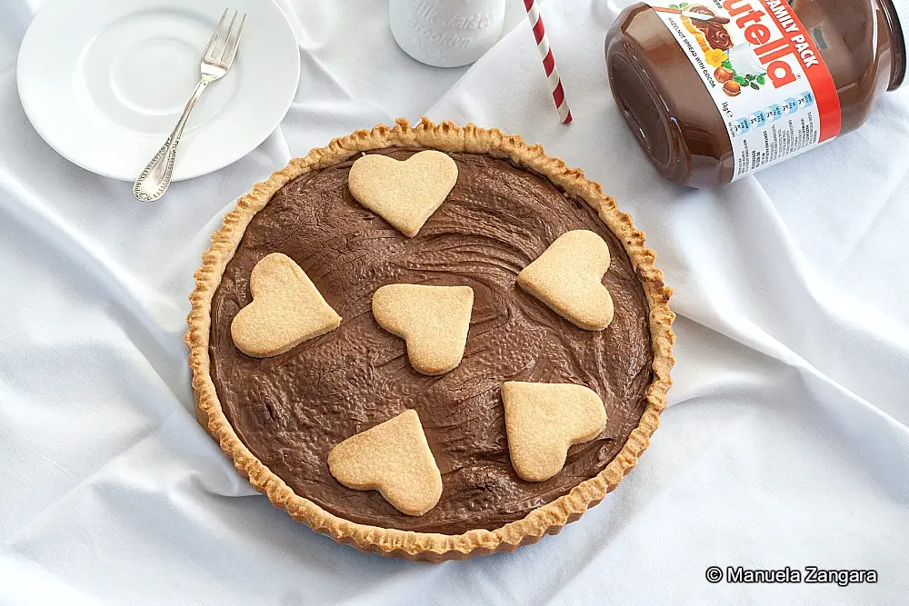 Finished Nutella Crostata topped with heart-shaped pastry decorations.