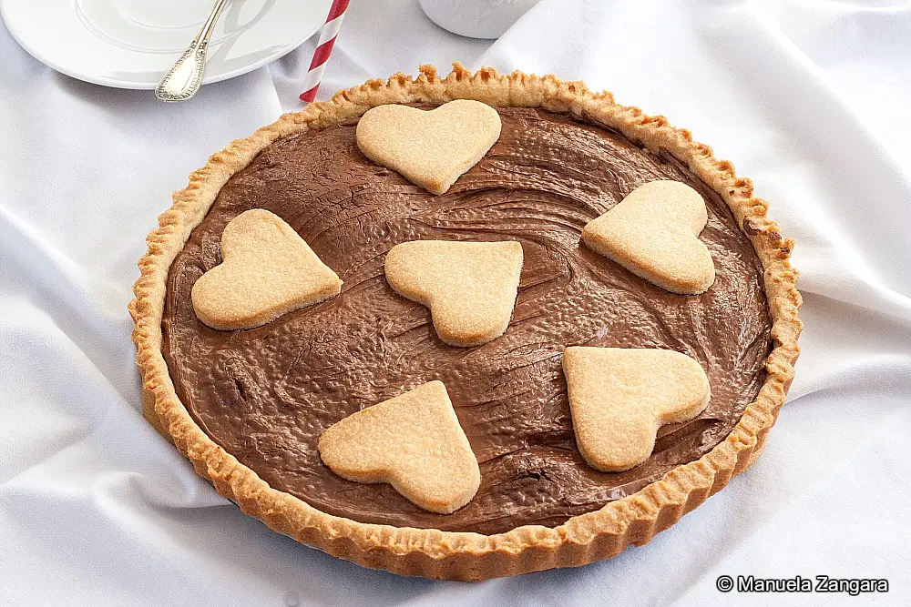 Close-up of the baked crostata showing the heart pastry decorations.