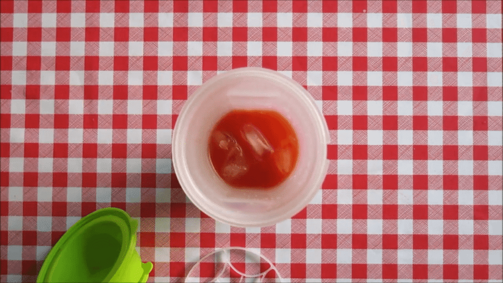 Tomato juice and ice in a shaker, ready to mix.