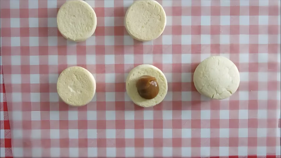 Filling sandwich cookies with Dulce de Leche before assembling.